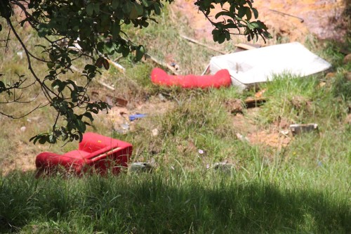 Erosão, mato alto, sofás e colchão no terreno próximo da Vila Matilde